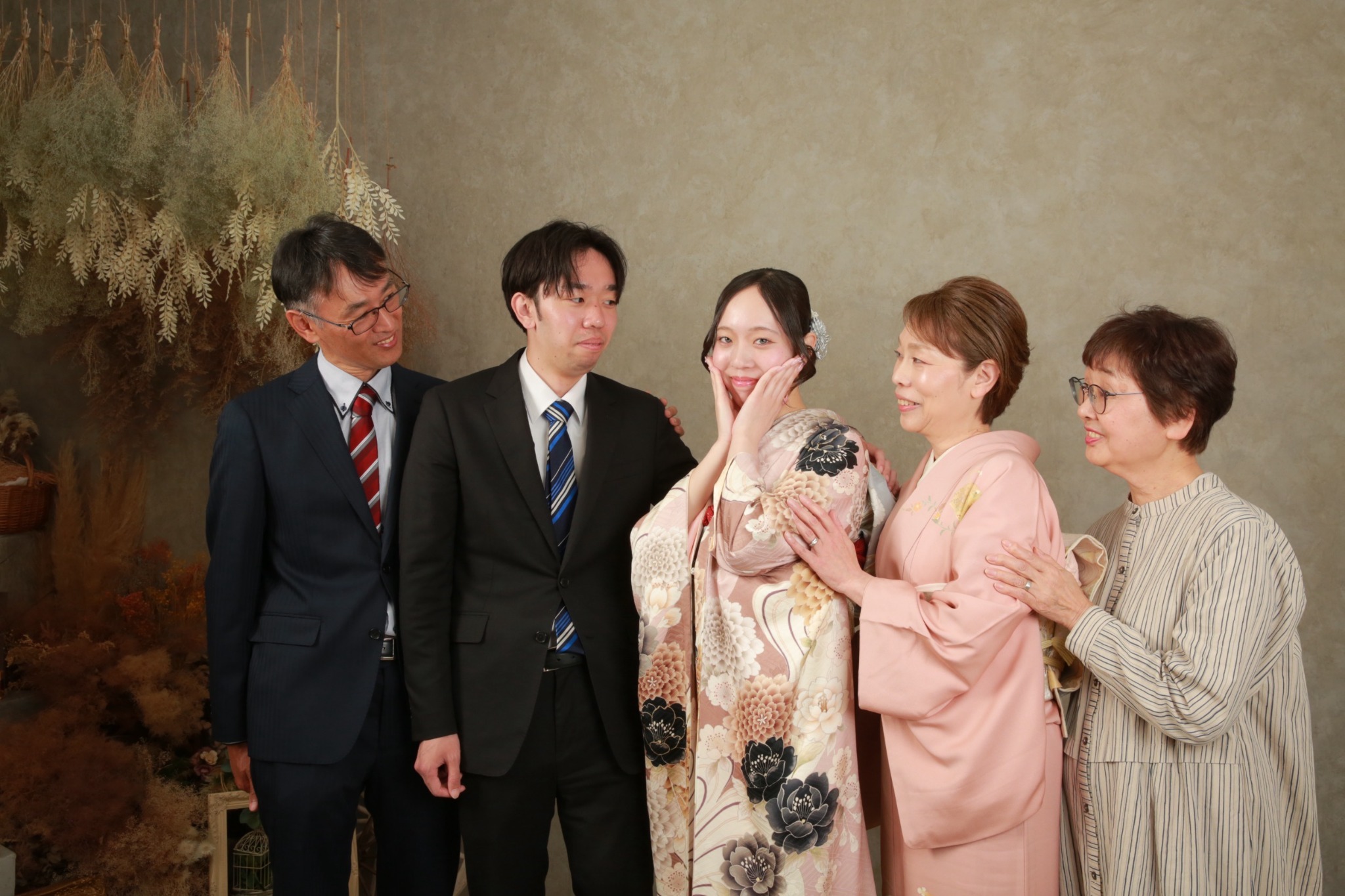 振袖姿のお嬢様を囲む自然体の家族写真